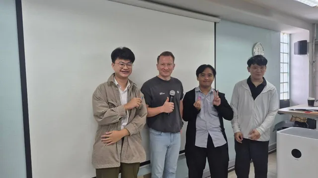 Vladislav Guzey and three students posing at the front of the CMU workshop room