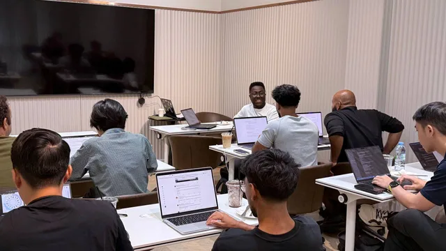 Developers working with Codex on their laptops during the OpenAI Build Week session in Chiang Mai