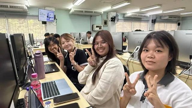 Four participants smiling at their desks during the Codex workshop at Chiang Mai University