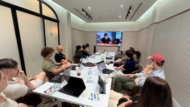 OpenAI demo playing on the meeting room screen, with laptops open around the table